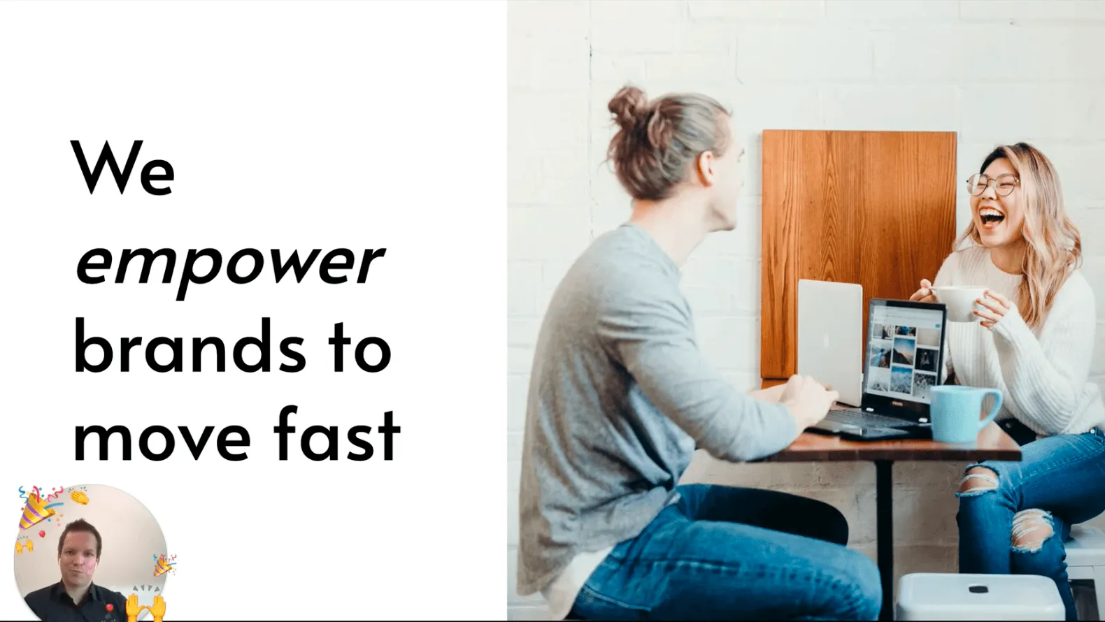 On the left side a text "We empower brands to move fast". On the right, two people sit across from each other with a notebook and a cup of coffee, laughing.