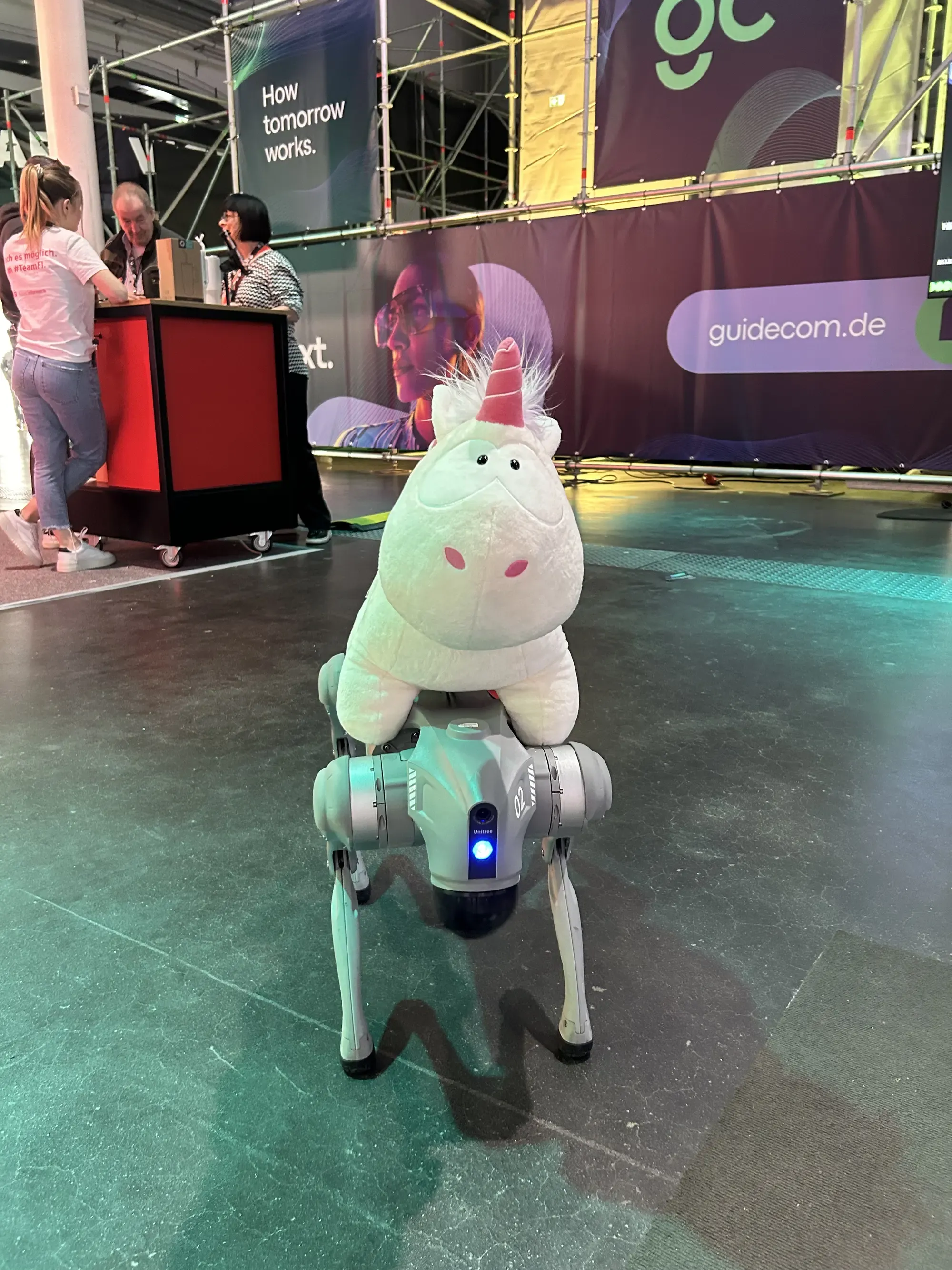 The unicorn from our unicorn giveaway is sitting on a robot dog.