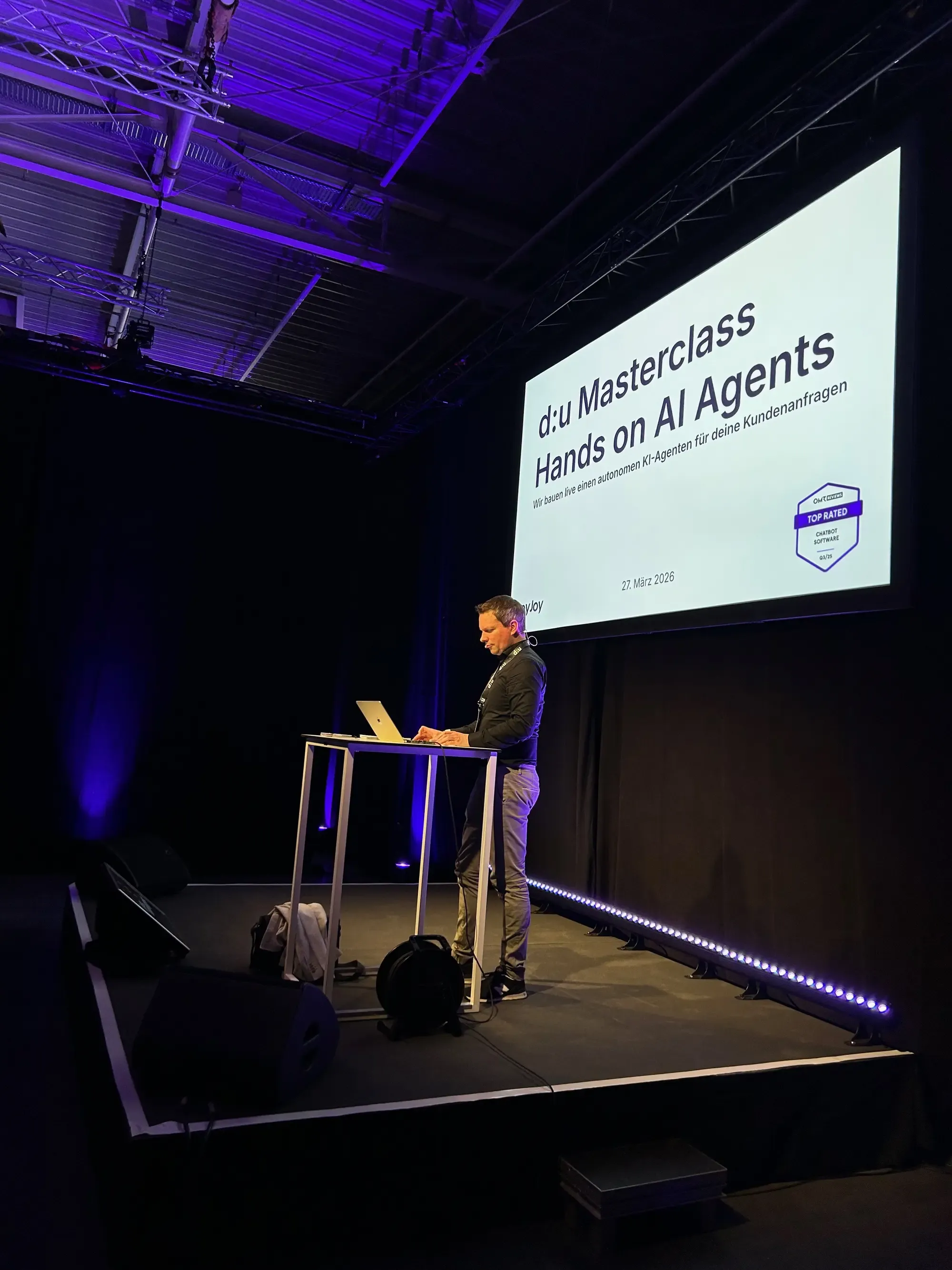 Unser CEO Ulf steht auf der Bühne bei unserer Masterclass und zeigt den Besuchern, wie man einen Chatbot in Minuten selber bauen kann.