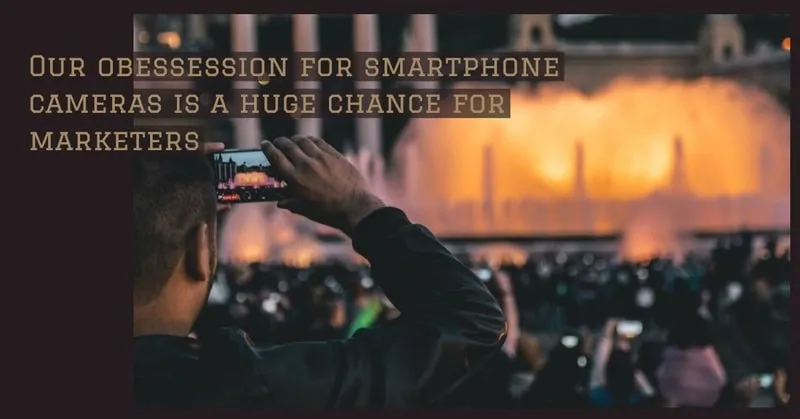 Ein Mann filmt ein Konzert oder eine Theateraufführung mit seinem Smartphone.