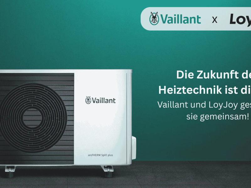 The image shows a modern heat pump from Vaillant against a green background with the text: 'The future of heating technology is digital: Vaillant and LoyJoy are shaping it together!'.
